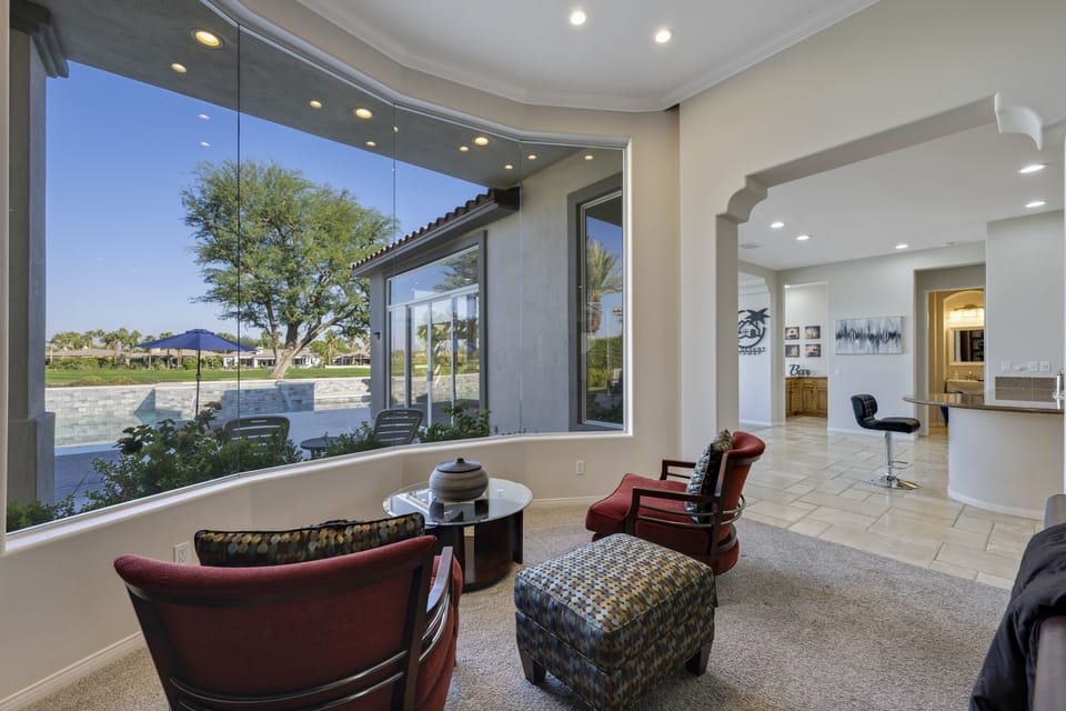 Sitting area adjacent to open concept kitchen, family and dining rooms with wet 