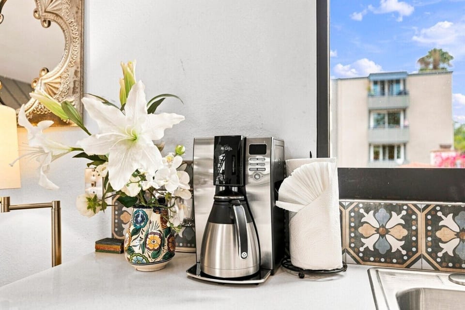 Fully stocked coffee station ☕ Drip coffee maker, mugs, and coastal tile accents.