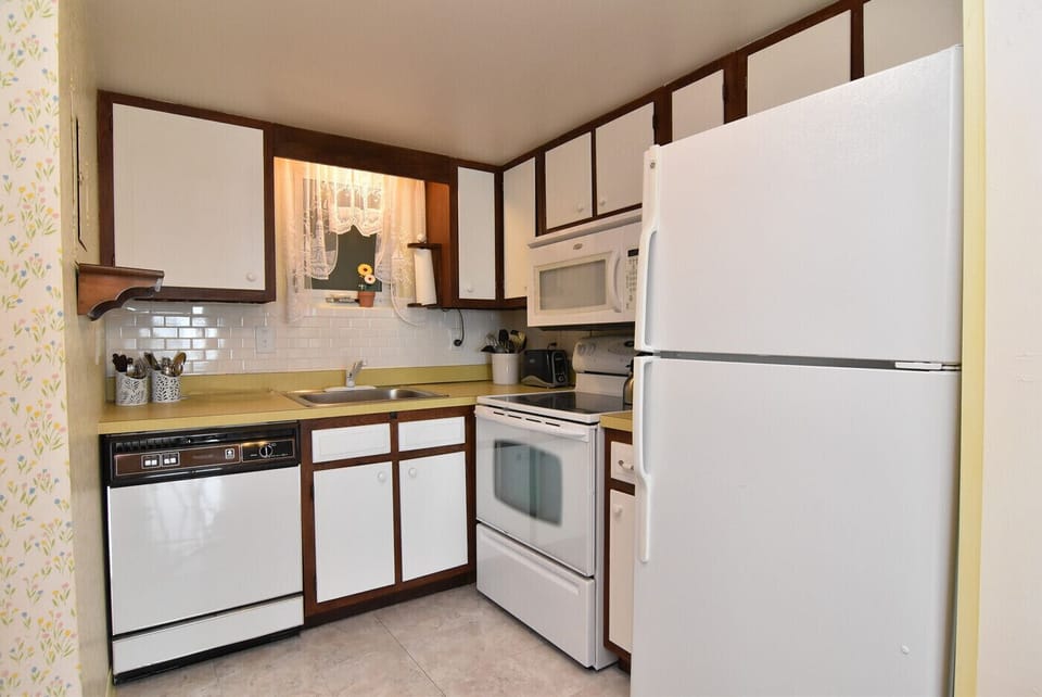 Kitchen w/ stainless sink, dishwasher, glass-top stove, refrigerator & microwave