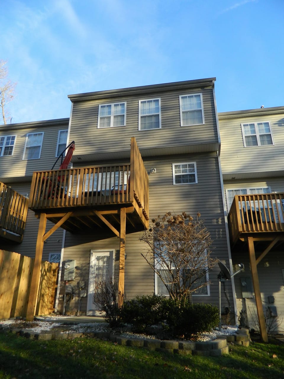 View of the back of the home with concrete patio and balcony/deck shown