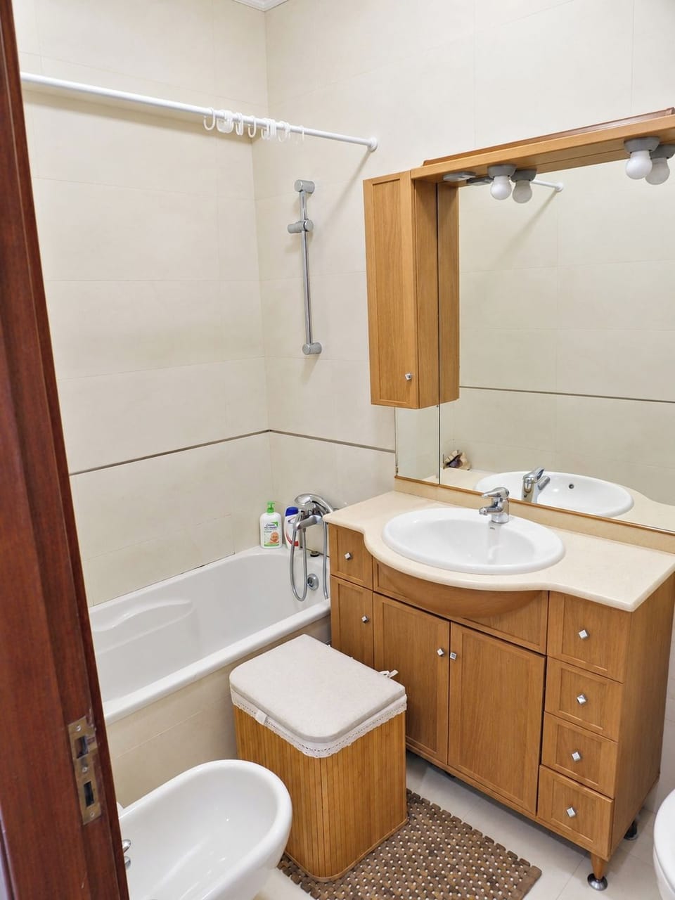 Bathroom with bathtub, vanity unit and practical storage.