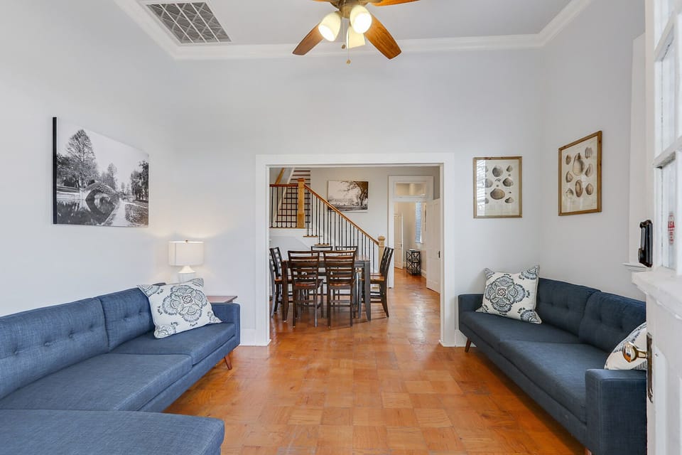 The living room has a large sectional sofa and 60” flat-screen TV