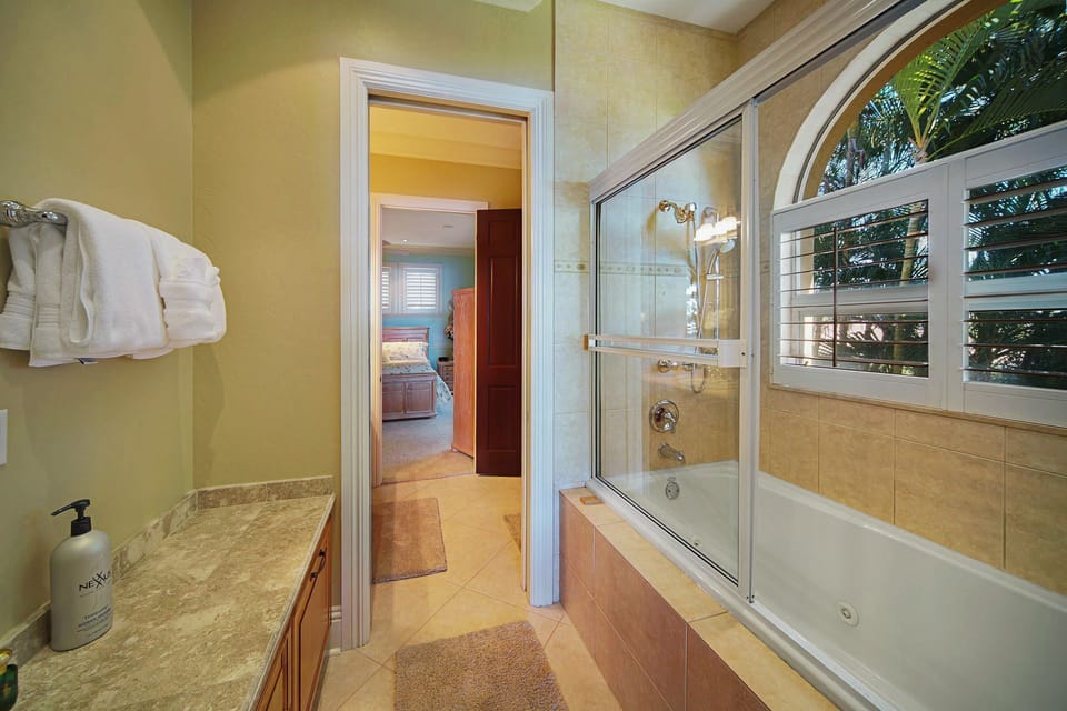 The shared Jack & Jill bath is thoughtfully designed with two separate vanity areas and a shared shower — privacy without compromise.