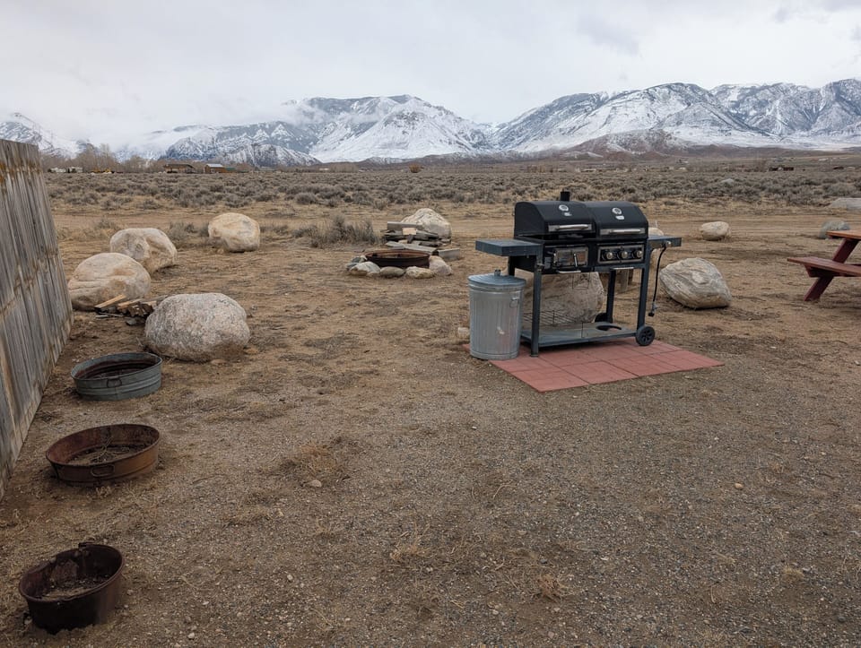 A view of the BBQ area, fire pit and the snow covered Beartooth Mountains