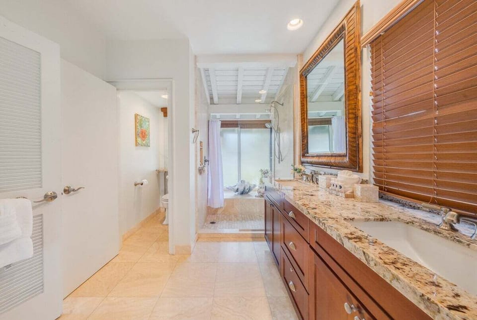 Experience comfort in a bathroom with granite vanity and glass shower.