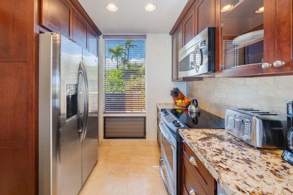 Prepare meals in a spacious kitchen with premium appliances and greenery views.