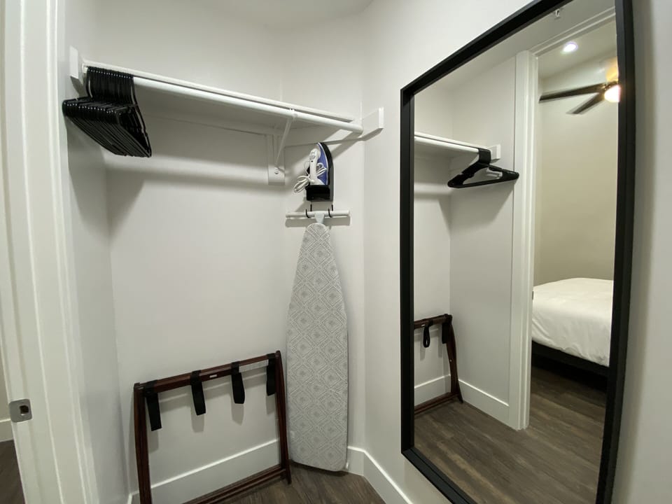 Guest closet with full length mirror and ironing needs. 
