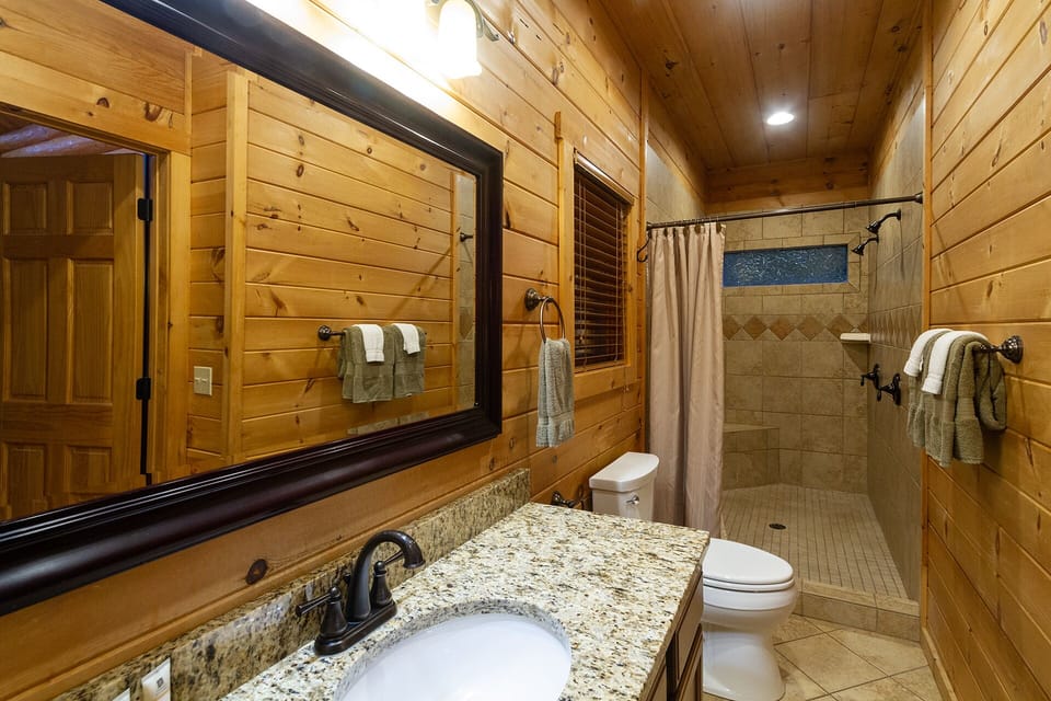 Master bathroom has a couples shower with dual heads and bench seat