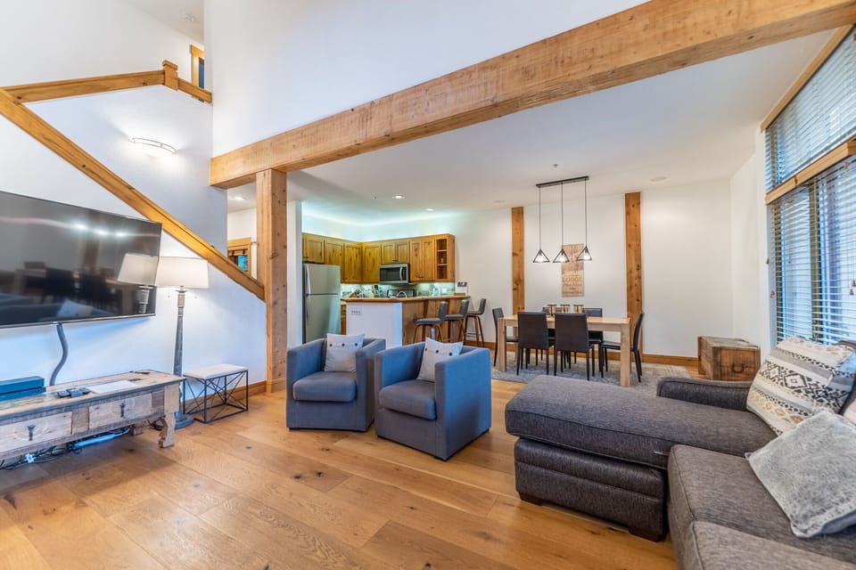 Relax in your spacious living area with exposed wood beams, cozy seating, and an open kitchen perfect for memorable meals together.