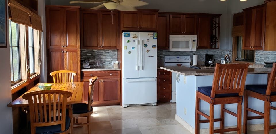 solid wood cabinets, teak furniture and granite make for a beautiful kitchen