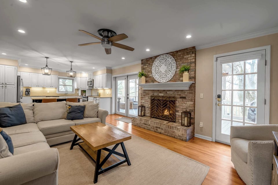 Enjoy time together in this harmonious setting, complete with a rustic fireplace, neutral tones, and a smooth flow to the kitchen and outdoors.