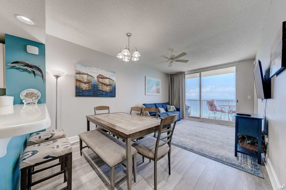 【Dining + Living Area】 Table seats 6 — balcony doors open behind you to direct Gulf views.
