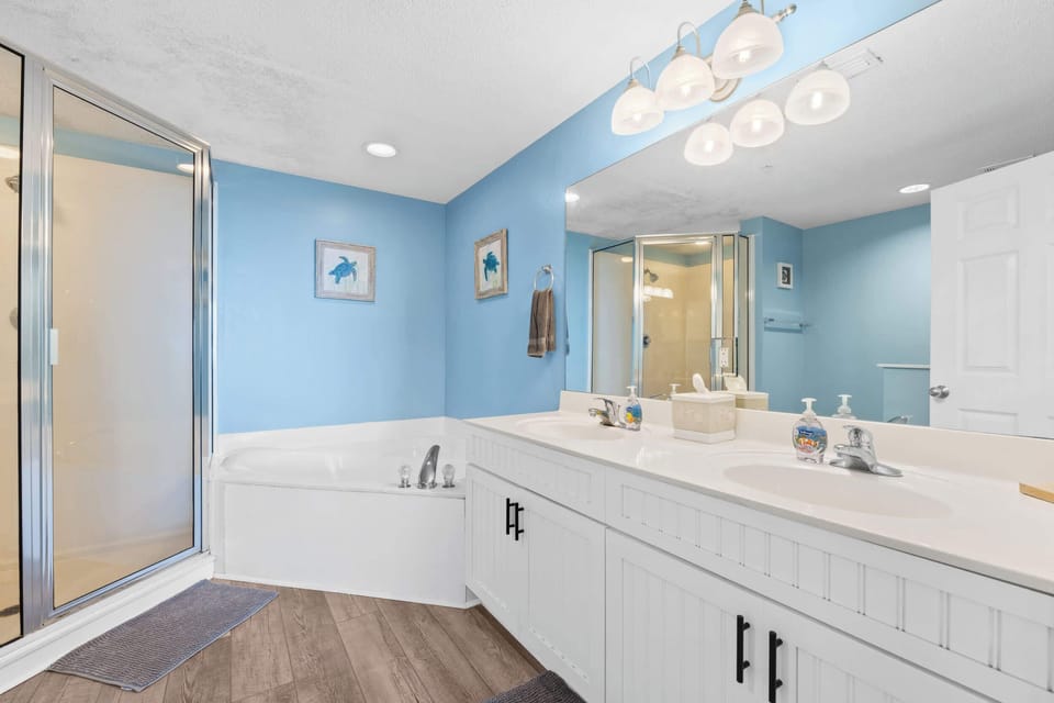 【En-Suite Bath】 Double vanity, blue accent wall — private bath off the king bedroom, freshly stocked.