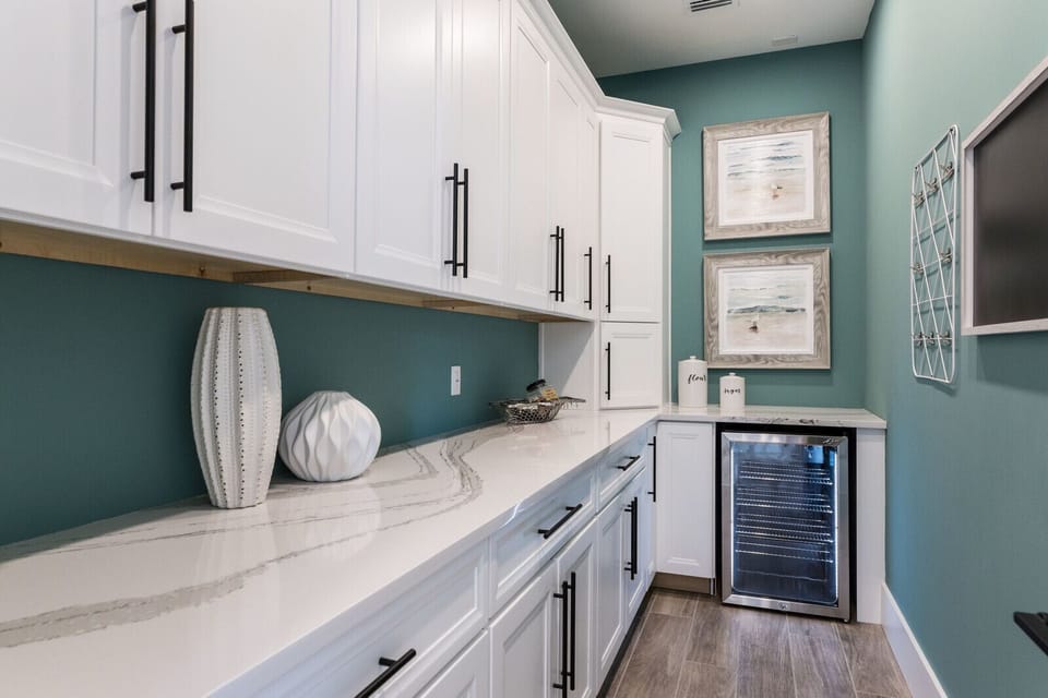 Butler's pantry behind the kitchen has extra countertop space and beverage fridge