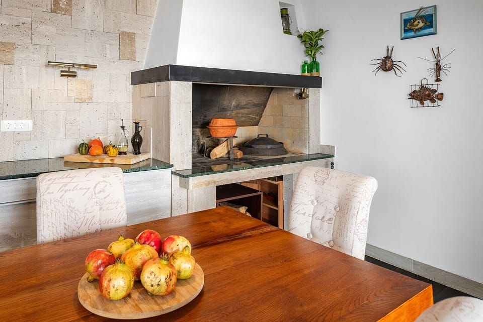 Beautiful indoor fireplace (peka/grill), emphasizing the dedicated space for traditional cooking and entertaining