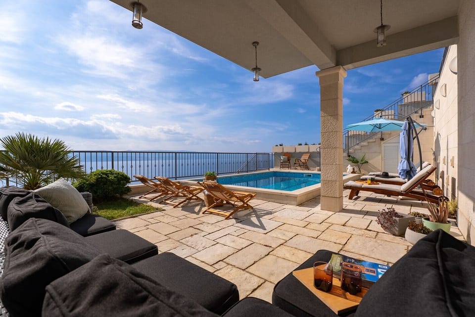 The covered part of the terrace offers a comfortable shaded outdoor living area, perfect for socializing by the pool