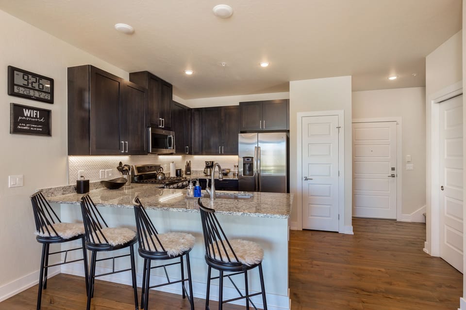 Step into your sleek kitchen where granite counters and modern appliances await your culinary adventures, with stylish bar seating perfect for morning coffee.