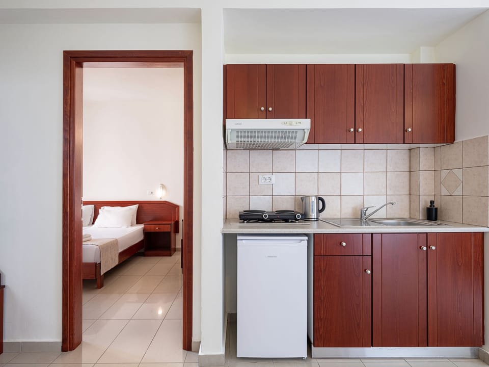 Deluxe Apartment, Pool View | Private kitchen | Fridge, stovetop, coffee/tea maker, electric kettle