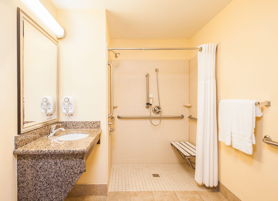 Suite, 1 Bedroom, Accessible (2 Qn, Comm, Roll Shwr) | Bathroom | Free toiletries, hair dryer, towels