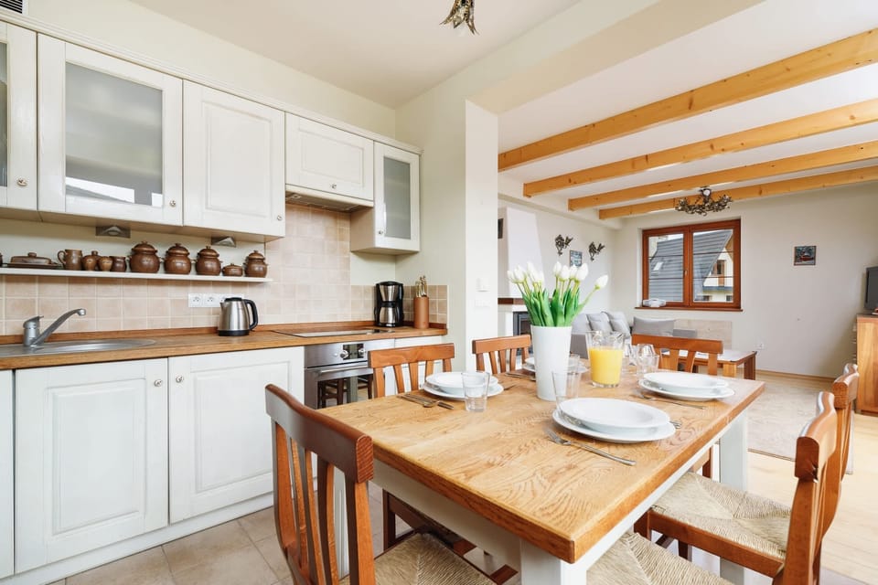 Another perspective of the dining area with the wooden table, chairs, and decorative items in a cabinet.