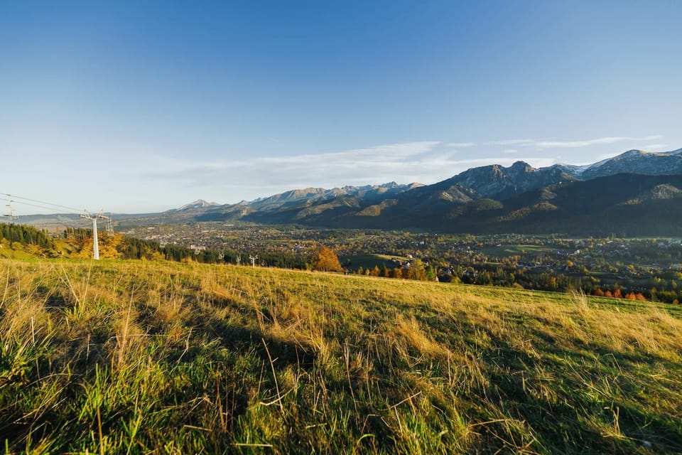 A zoomed-in view of rugged mountain peaks and grassy fields.
