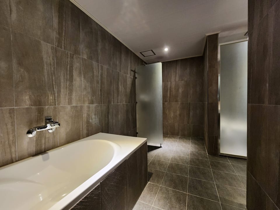 Shower, rainfall showerhead, slippers, towels