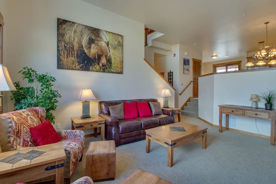 Unwind in your spacious living room with comfy leather seating, warm lighting, and rustic mountain charm that makes you feel instantly at home.