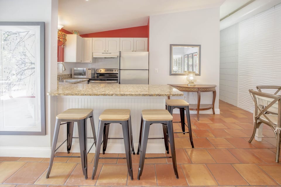 Kitchen breakfast bar with seating for four and modern painting.