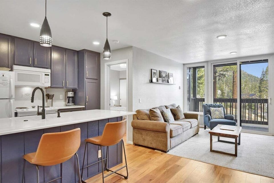 Kitchen with additional seating at the bar, open to the living room