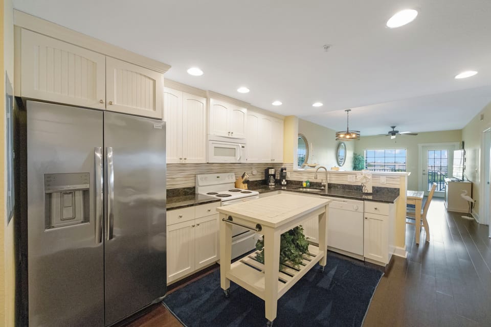 Kitchen - fully equipped w/ a microwave, dishwasher, full size fridge, Mr. Coffee, range, stackable washer/dryer, pots/pans, dishes and silverware.