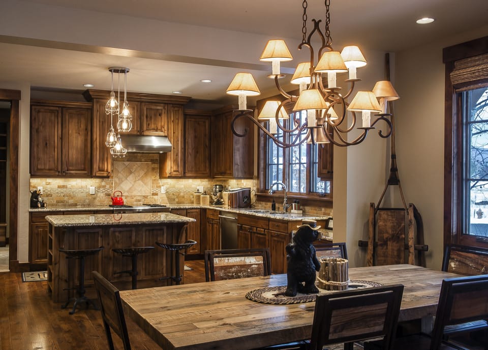 Gather around this stunning rustic kitchen where your culinary adventures await. Rich wood cabinets and granite counters create a warm, homey feel while the elegant chandelier sets the perfect mood for memorable meals together.