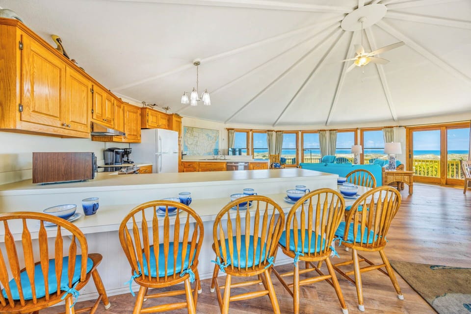Gather around the spacious island where meals become memories, as warm wood tones meet cool ocean blues visible through every window of this sun-drenched coastal haven.