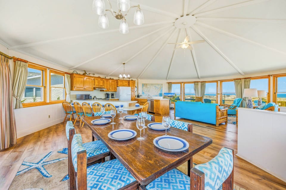 Gather around the dining table where ocean breezes meet warm wood tones, and every meal becomes a memory framed by stunning sea views and coastal sunlight.