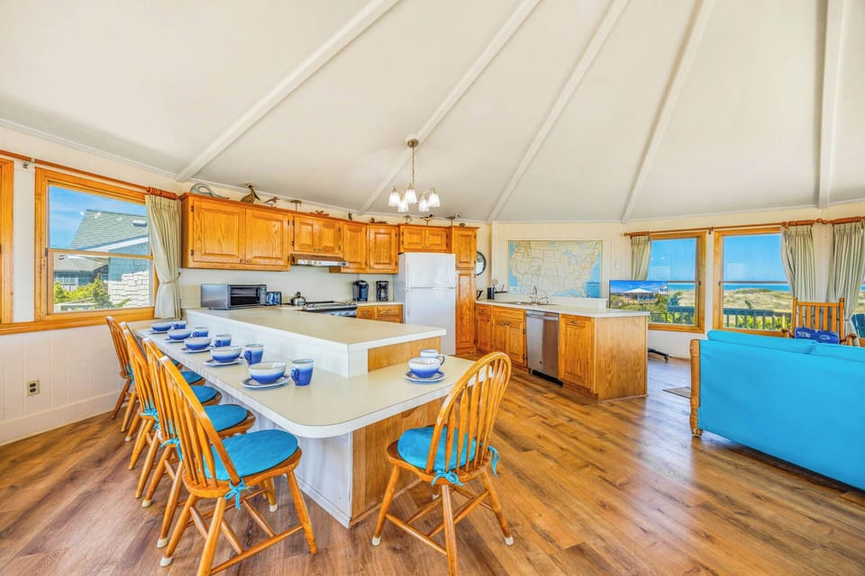 Gather with loved ones in your spacious, sunlit kitchen where ocean views frame every meal. Natural wood and coastal charm create the perfect backdrop for shared moments over home-cooked feasts.