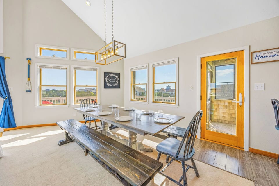 Gather around this bright dining area with soaring vaulted ceilings and plenty of natural light. Large windows frame coastal views, perfect for memorable meals together.