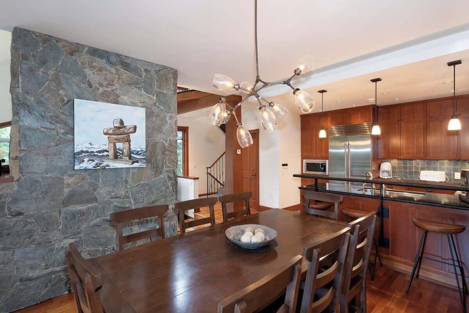 - Elegant dining area beside a rustic stone accent wall  
- Warm lighting and mountain-inspired décor create cozy charm  
- Perfect spot for family dinners after a day on the slopes  