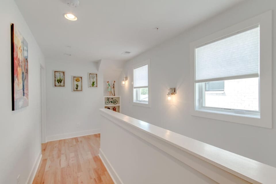 Upper landing with framed wall art and natural light from windows