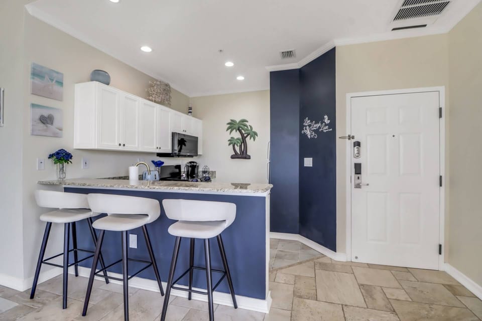 An eating bar with bar stools separates the kitchen from the living area.