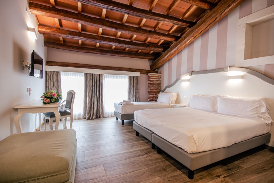 Triple Room | Minibar, in-room safe, individually decorated, desk