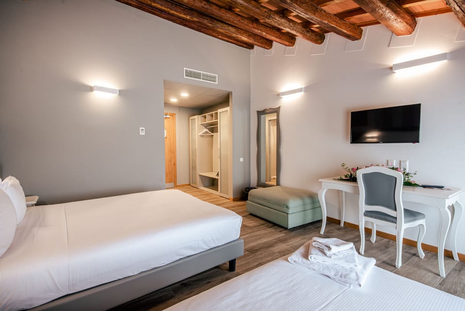Triple Room | Minibar, in-room safe, individually decorated, desk