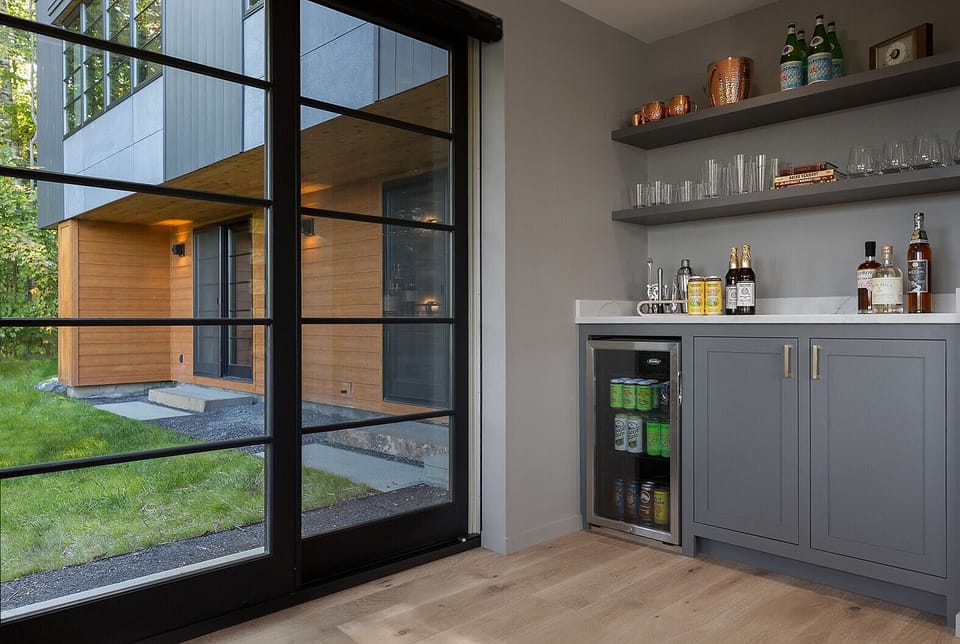 family room bar with sliders leading to the outdoor seating area and hot tub