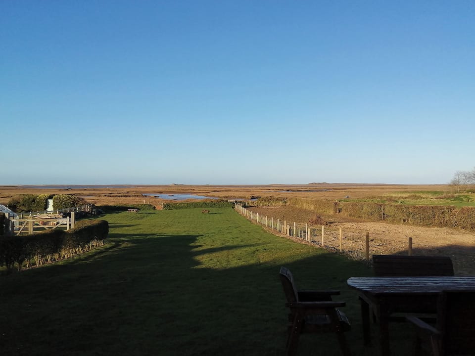 Far reaching views over the garden and slat marsh beyond | Vista Cottage, Dale View - Sea Marsh Cottages, Brancaster Staithe, near Wells-next-the-Sea