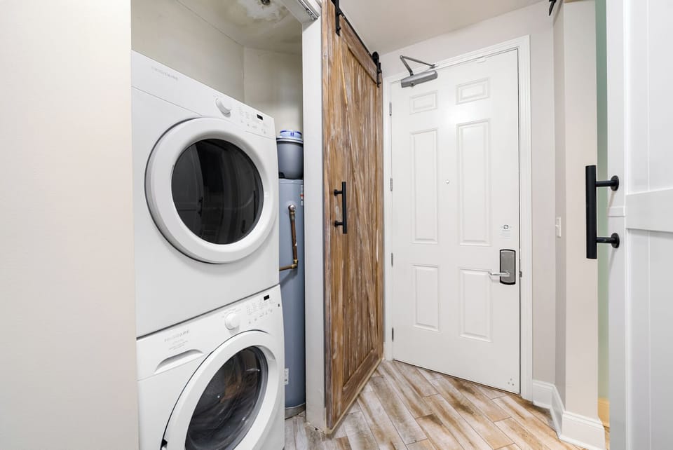 Keep your travel wardrobe fresh in this convenient laundry area with stacked washer and dryer, complete with charming barn door details.
