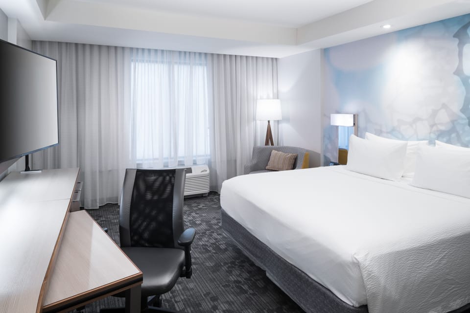 Premium bedding, desk, laptop workspace, blackout drapes
