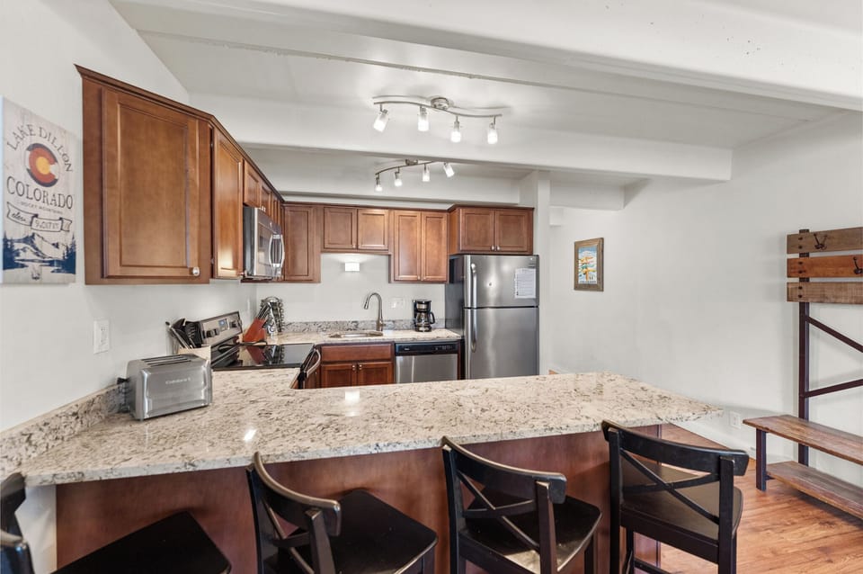 Your fully equipped kitchen features granite countertops, stainless steel appliances, and a breakfast bar perfect for morning coffee or evening meals.