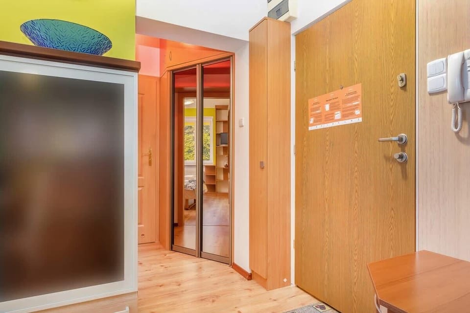 The hallway inside the apartment, with wooden storage cabinets and bright lighting.