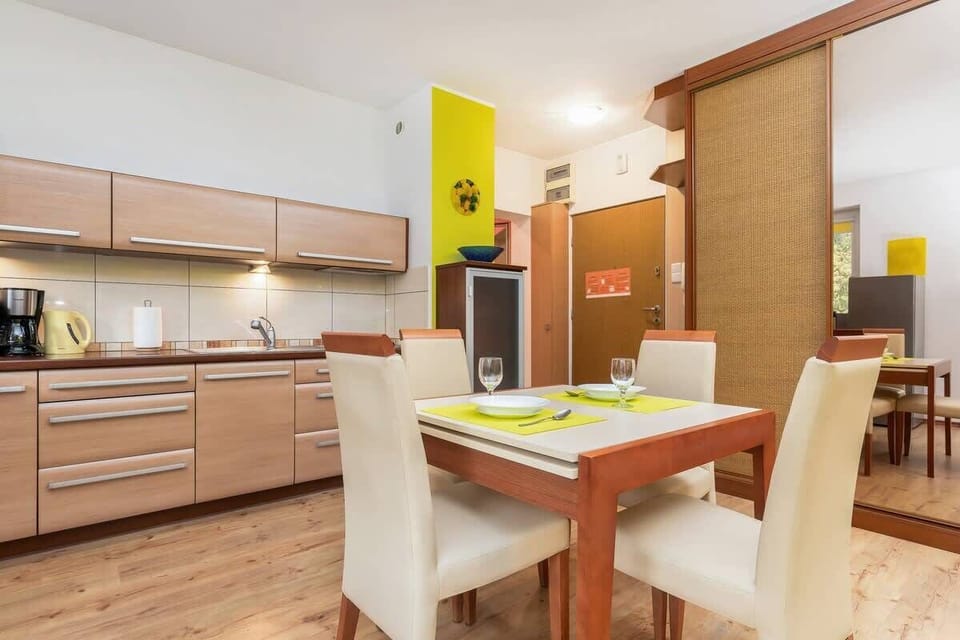 A closer look at the dining area with a table and chairs, adjacent to the kitchen space.