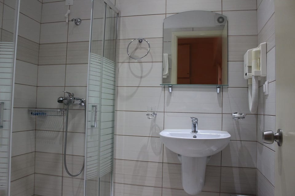 Standard Twin Room | Bathroom | Rainfall showerhead, hair dryer, towels