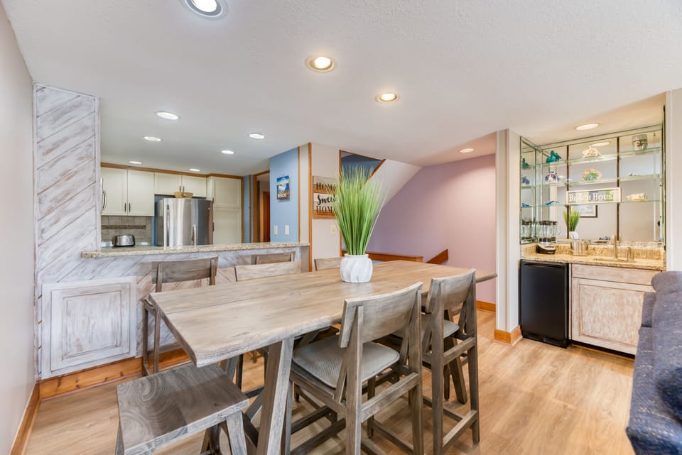 Dining room table w/ view of wet bar and kitchen