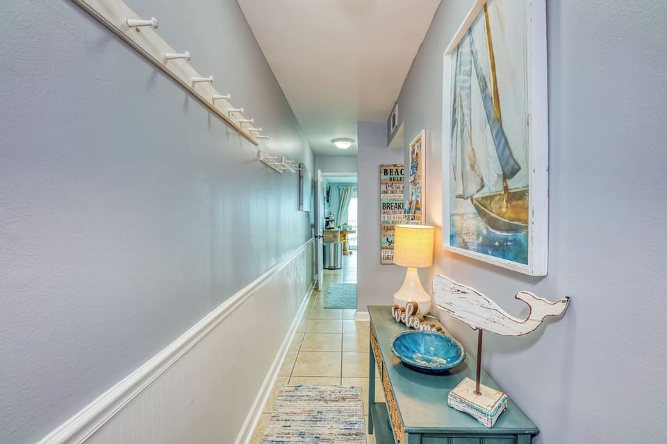 A console table greats you upon walking into the unit. This the perfect place to put your car keys and other items from your pocket. On the opposite wall we have a ton of wall hangs perfect for towels or swimsuits.